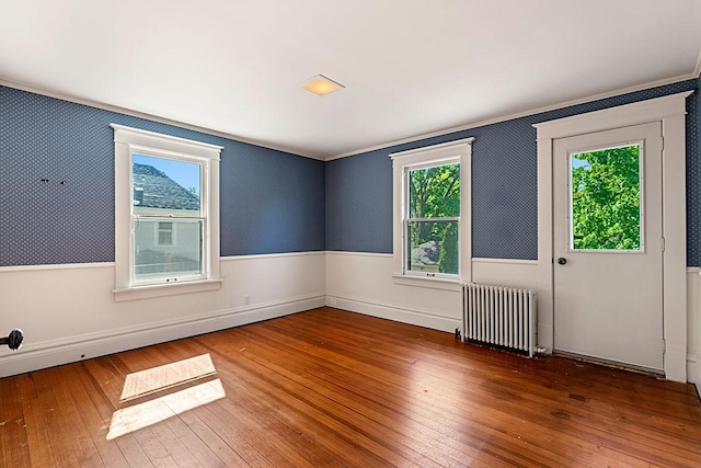 408 5th St E, Northfield, MN 55057 - spare room with radiator heating unit, wood-type flooring, and crown molding