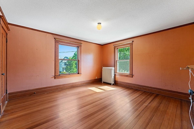 408 5th St E, Northfield, MN 55057 - spare room with radiator, hardwood / wood-style floors, ornamental molding, baseboards, and a textured ceiling