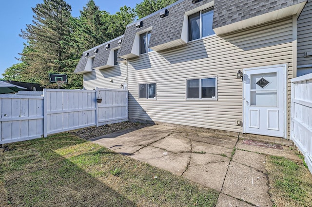 3944 76th Way E, Inver Grove Heights, MN 55076 - rear view of house with a shingled roof, mansard roof, and a patio area