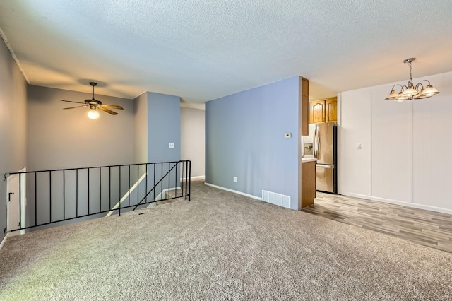 3944 76th Way E, Inver Grove Heights, MN 55076 - empty room with light carpet, a textured ceiling, baseboards, a chandelier, and a ceiling fan