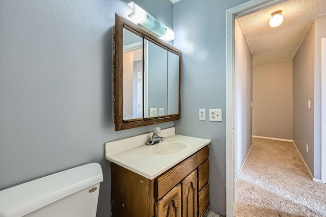 3944 76th Way E, Inver Grove Heights, MN 55076 - bathroom with toilet, vanity, baseboards, and a textured ceiling