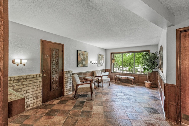 2200 Nevada Ave S Unit 320, Saint Louis Park, MN 55426 - living area featuring a textured ceiling, stone tile floors, wainscoting, and a textured wall