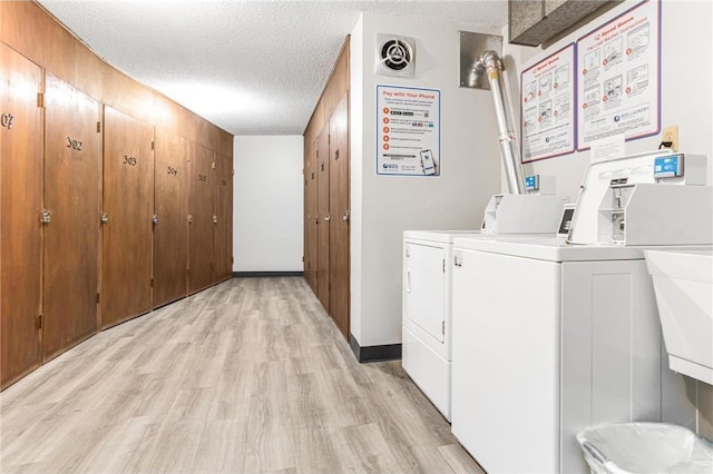 2200 Nevada Ave S Unit 320, Saint Louis Park, MN 55426 - community laundry room featuring washing machine and clothes dryer, a textured ceiling, and light wood-style floors