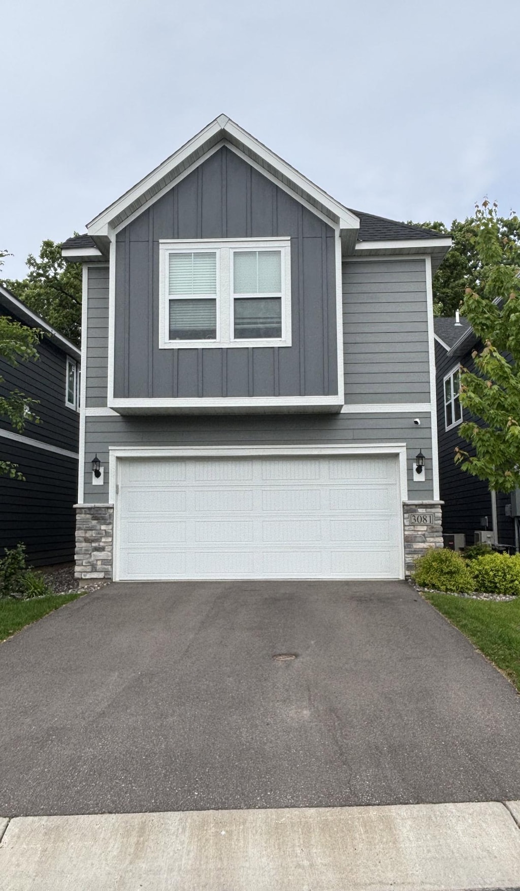 3081 Rum River Way, Anoka, MN 55303 - view of front of property with a garage, stone siding, and board and batten siding