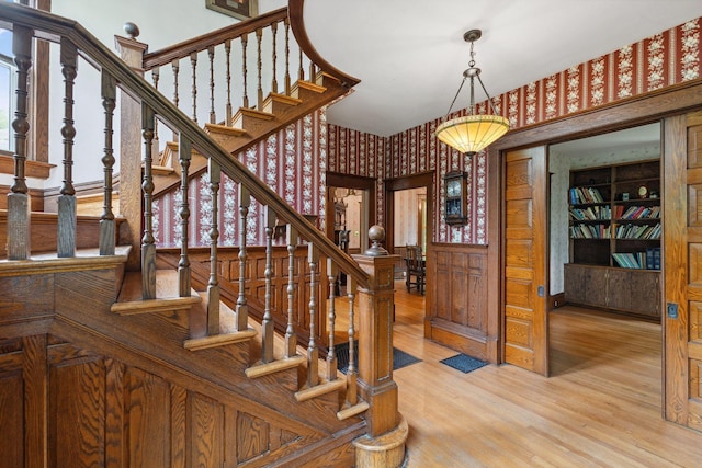 216 Summit Ave, Center City, MN 55012 - stairs featuring wallpapered walls, wood finished floors, and wainscoting