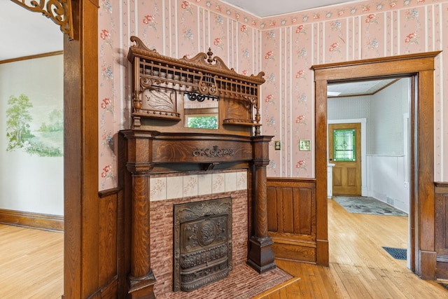 216 Summit Ave, Center City, MN 55012 - detailed view of wallpapered walls, wood finished floors, wainscoting, a fireplace with flush hearth, and ornamental molding