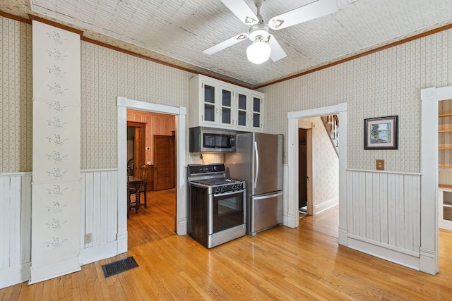 216 Summit Ave, Center City, MN 55012 - kitchen with ornamental molding, appliances with stainless steel finishes, wallpapered walls, a wainscoted wall, and ceiling fan