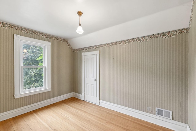 216 Summit Ave, Center City, MN 55012 - empty room featuring light wood-type flooring, vaulted ceiling, wallpapered walls, and baseboards