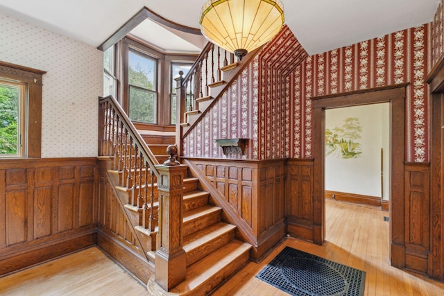 216 Summit Ave, Center City, MN 55012 - stairway featuring wallpapered walls, hardwood / wood-style flooring, and a wainscoted wall