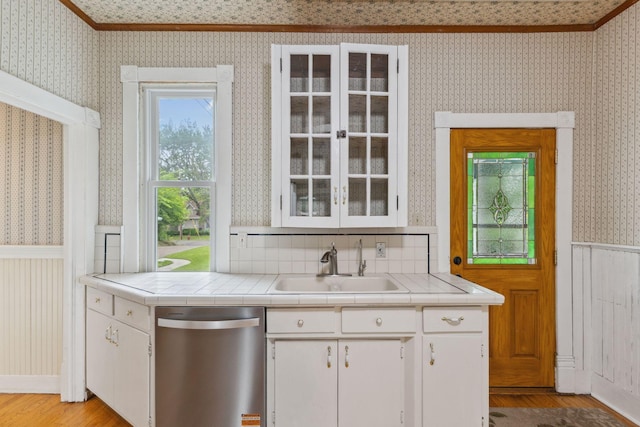 216 Summit Ave, Center City, MN 55012 - kitchen featuring stainless steel dishwasher, wallpapered walls, tile countertops, wainscoting, and light wood-type flooring