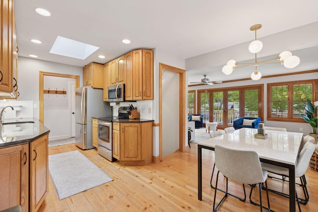 1709 Baywood Ln, Mound, MN 55364 - kitchen with appliances with stainless steel finishes, a sink, a skylight, light wood-type flooring, and recessed lighting