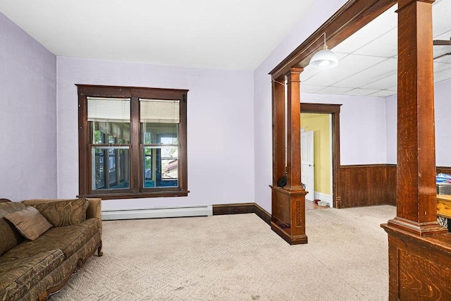 2718 3rd St, Duluth, MN 55806 - living area featuring decorative columns, a baseboard heating unit, carpet floors, wood walls, and a wainscoted wall