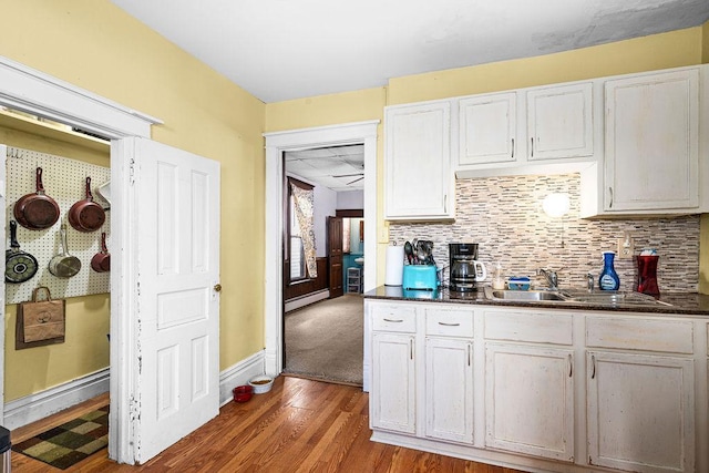 2718 3rd St, Duluth, MN 55806 - kitchen with dark wood-style floors, baseboard heating, dark countertops, a sink, and backsplash