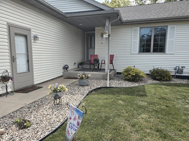 1612 17th St SW, Austin, MN 55912 - view of exterior entry featuring a lawn and a shingled roof