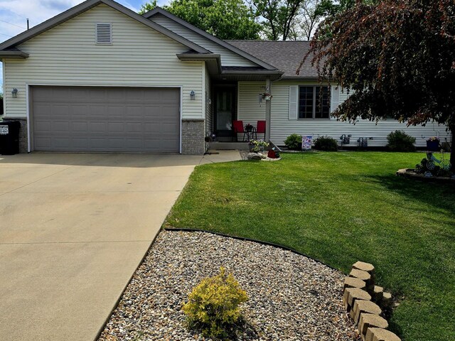 1612 17th St SW, Austin, MN 55912 - ranch-style house featuring an attached garage, driveway, a front yard, roof with shingles, and covered porch