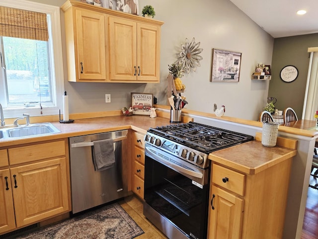 1612 17th St SW, Austin, MN 55912 - kitchen featuring appliances with stainless steel finishes, a peninsula, a sink, light brown cabinetry, and light countertops