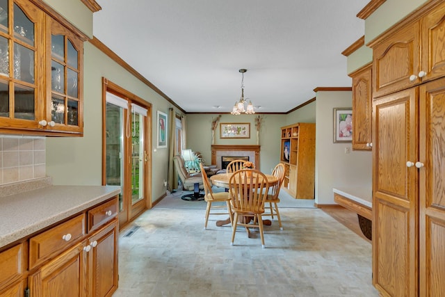 2904 Park Dr, Saint Cloud, MN 56303 - dining space with ornamental molding, a fireplace, and a chandelier