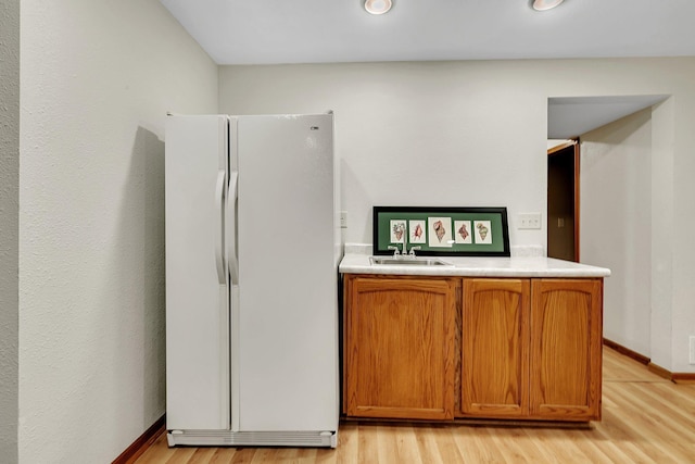 2904 Park Dr, Saint Cloud, MN 56303 - kitchen featuring freestanding refrigerator, light wood finished floors, light countertops, brown cabinetry, and recessed lighting