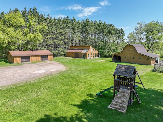 2444 County Rd 1, Wrenshall, MN 55797 - view of grassy yard featuring an outbuilding, a garage, dirt driveway, and a barn