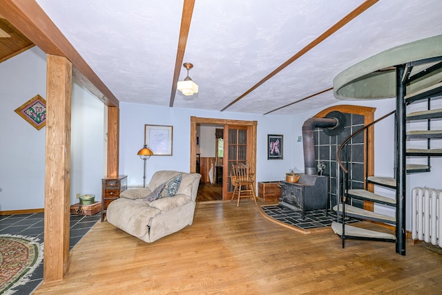 2444 County Rd 1, Wrenshall, MN 55797 - living area with stairs, a wood stove, radiator heating unit, and wood finished floors