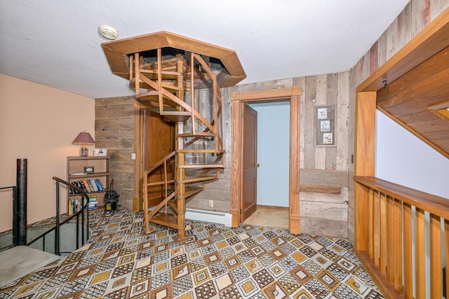 2444 County Rd 1, Wrenshall, MN 55797 - stairway featuring baseboard heating, wood walls, and a textured ceiling