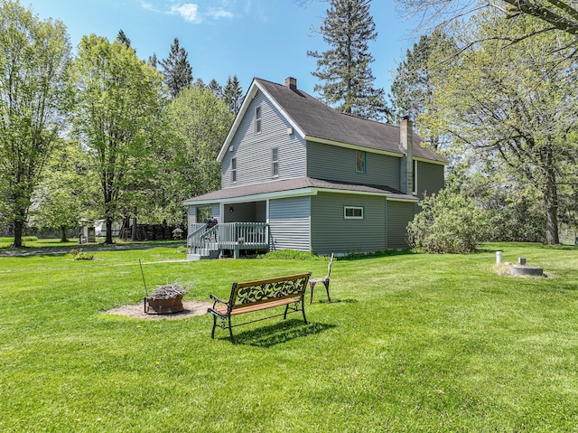 2444 County Rd 1, Wrenshall, MN 55797 - rear view of house with a fire pit, a chimney, a yard, and a wooden deck