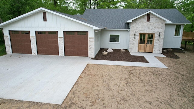 20482 Lord Rd, Center Twp, MN 56465 - modern farmhouse featuring roof with shingles, a garage, concrete driveway, board and batten siding, and stone siding