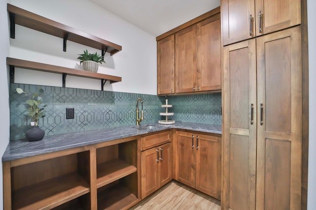 20482 Lord Rd, Center Twp, MN 56465 - kitchen featuring open shelves, decorative backsplash, light wood-style floors, light stone countertops, and brown cabinets