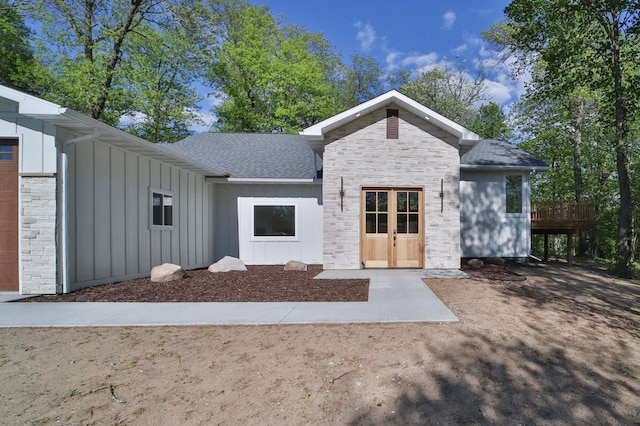 20482 Lord Rd, Center Twp, MN 56465 - view of front of property featuring board and batten siding, a shingled roof, a deck, and stone siding