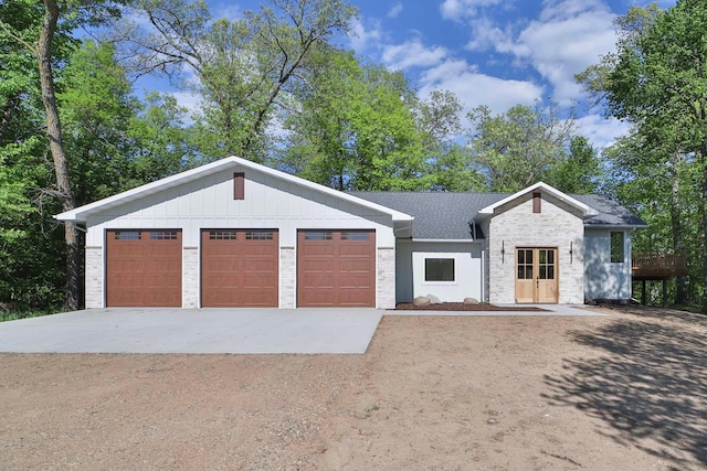 20482 Lord Rd, Center Twp, MN 56465 - view of front of house with driveway, a garage, stone siding, and board and batten siding