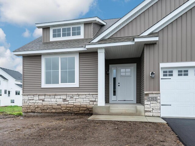 5393 177th St W, Lakeville, MN 55044 - entrance to property with a shingled roof, stone siding, and board and batten siding