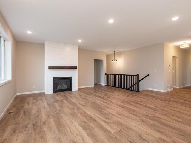 5393 177th St W, Lakeville, MN 55044 - unfurnished living room with light wood-style flooring, recessed lighting, baseboards, and a fireplace