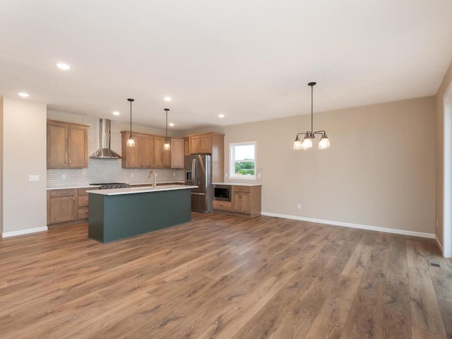 5393 177th St W, Lakeville, MN 55044 - kitchen featuring wall chimney range hood, appliances with stainless steel finishes, wood finished floors, a chandelier, and recessed lighting