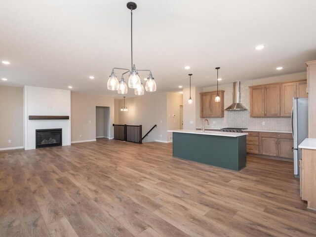 5393 177th St W, Lakeville, MN 55044 - kitchen featuring wall chimney exhaust hood, stainless steel appliances, recessed lighting, a kitchen island with sink, and light countertops