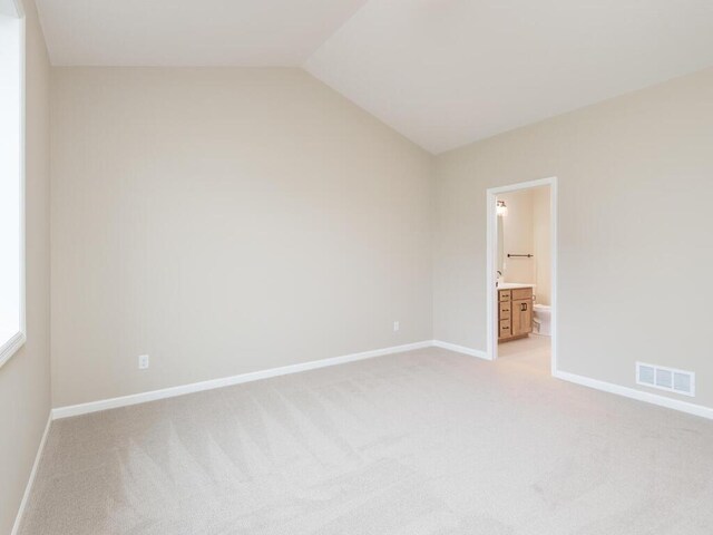 5393 177th St W, Lakeville, MN 55044 - unfurnished bedroom featuring light carpet, baseboards, lofted ceiling, and ensuite bath