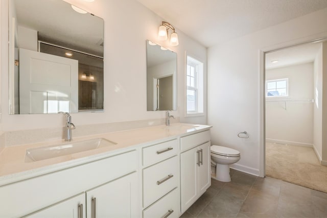 20098 67th Ave, Corcoran, MN 55340 - full bath featuring double vanity, toilet, baseboards, a spacious closet, and tile patterned floors