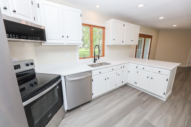 1202 Ridgeview Ter NE, Alexandria, MN 56308 - kitchen featuring appliances with stainless steel finishes, a sink, light wood-type flooring, light countertops, and recessed lighting