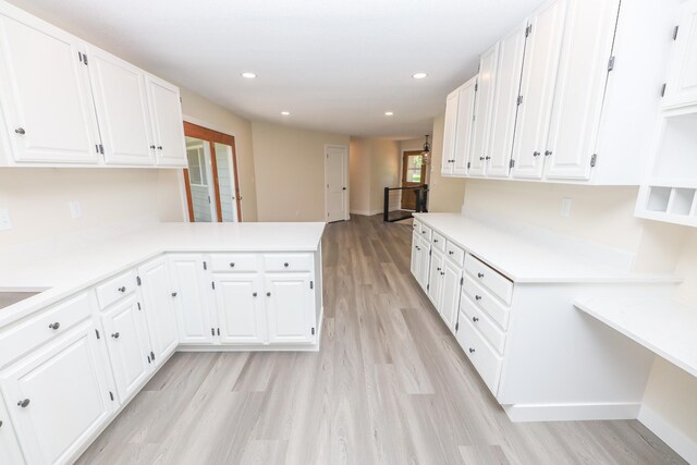 1202 Ridgeview Ter NE, Alexandria, MN 56308 - kitchen with light wood-style floors, white cabinetry, light countertops, a peninsula, and recessed lighting