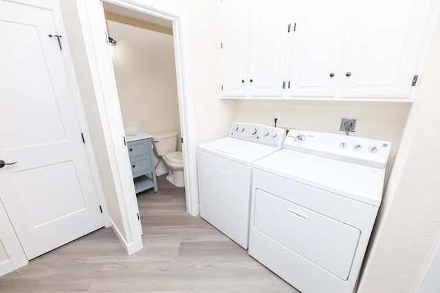 1202 Ridgeview Ter NE, Alexandria, MN 56308 - laundry area with washing machine and clothes dryer, light wood finished floors, cabinet space, and baseboards