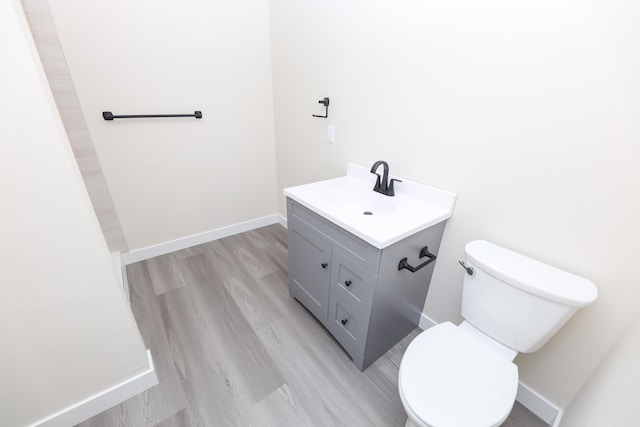 1202 Ridgeview Ter NE, Alexandria, MN 56308 - bathroom featuring vanity, toilet, wood finished floors, and baseboards