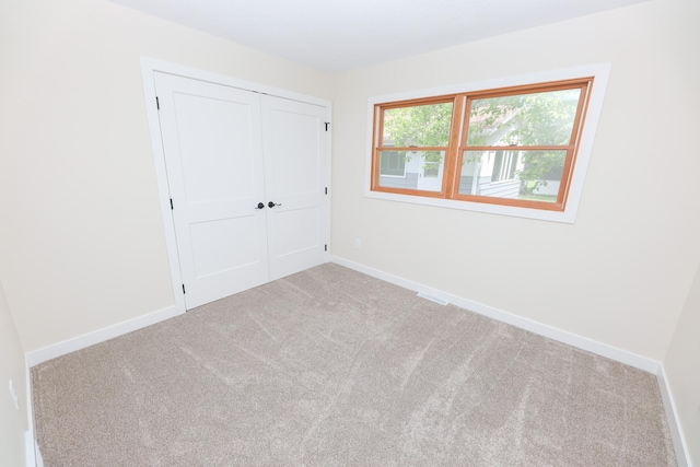 1202 Ridgeview Ter NE, Alexandria, MN 56308 - unfurnished bedroom featuring carpet floors, a closet, and baseboards