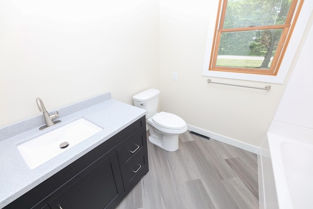 1202 Ridgeview Ter NE, Alexandria, MN 56308 - full bath featuring toilet, vanity, a bathtub, wood finished floors, and baseboards