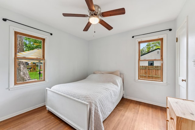 2918 Asbury St, Roseville, MN 55113 - bedroom with baseboards, light wood-type flooring, multiple windows, and ceiling fan