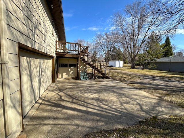 1646 5th St, Montevideo, MN 56265 - view of side of property featuring stairway, a deck, and driveway