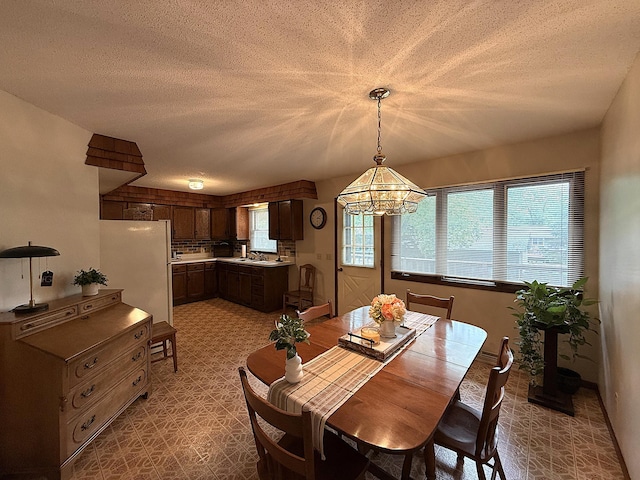 1646 5th St, Montevideo, MN 56265 - dining area with a textured ceiling, a chandelier, and light floors