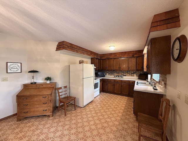 1646 5th St, Montevideo, MN 56265 - kitchen featuring white appliances, light countertops, a sink, a textured ceiling, and tasteful backsplash
