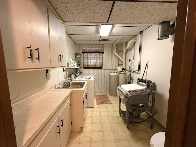 1646 5th St, Montevideo, MN 56265 - kitchen featuring washing machine and clothes dryer, light flooring, a sink, a drop ceiling, and light countertops