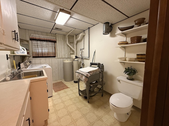 1646 5th St, Montevideo, MN 56265 - washroom with separate washer and dryer, light flooring, wood walls, and baseboards