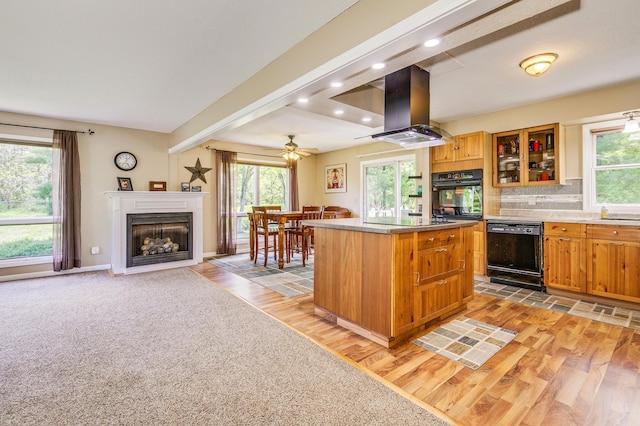 4230 Odegard Ave N, Baytown Twp, MN 55082 - kitchen featuring black appliances, island range hood, light wood-type flooring, a kitchen island, and plenty of natural light