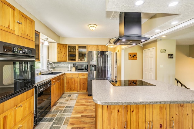 4230 Odegard Ave N, Baytown Twp, MN 55082 - kitchen with black appliances, island range hood, a sink, light wood-type flooring, and a kitchen island